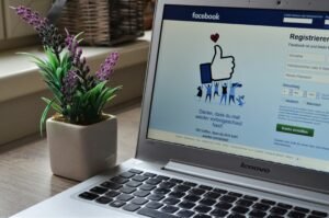 pexels-photo-927629-927629 A Lenovo laptop displaying Facebook login beside a lavender plant indoors.